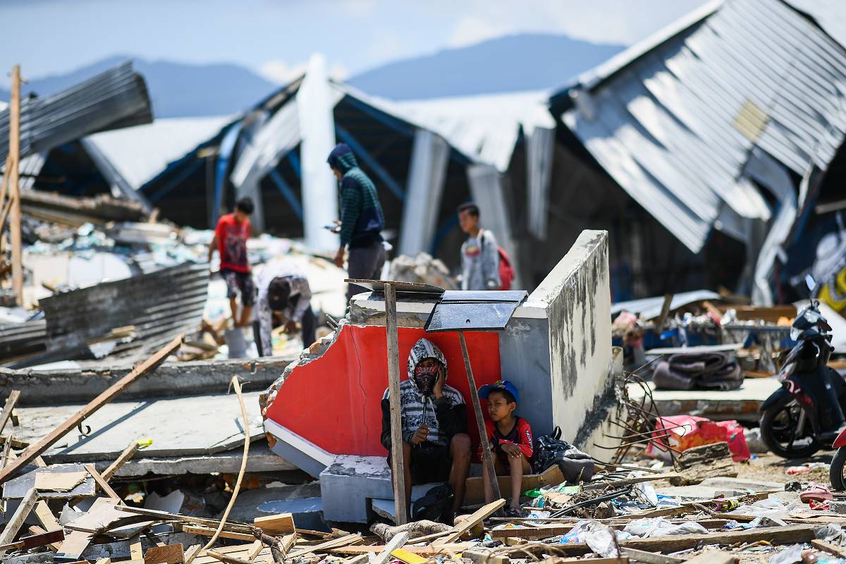 Earthquakes People sit, and forage amongst the ruins after an earthquake